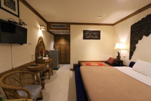 a hotel room with a bed and a television at Right Spot in Pattaya South