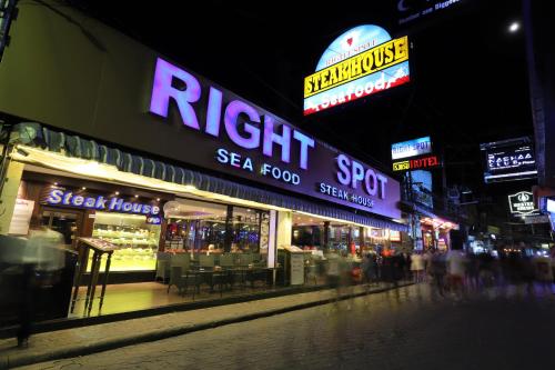 a city street at night with neon signs at Right Spot in Pattaya South
