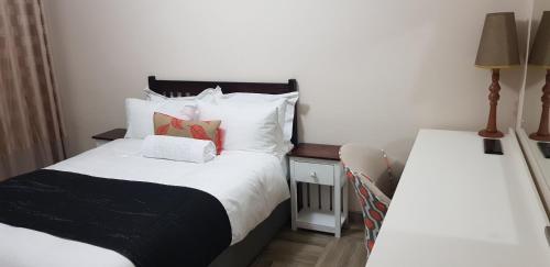 Un pequeño dormitorio con 2 camas y una falda. en One Oban Place, en Pinetown