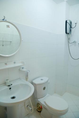 a white bathroom with a toilet and a sink at Nisala Guest in Galle
