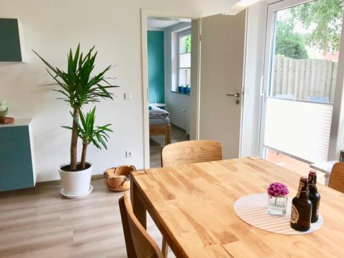 a dining room with a wooden table and a potted plant at Ferienwohnung Alsterbogen in Flensburg