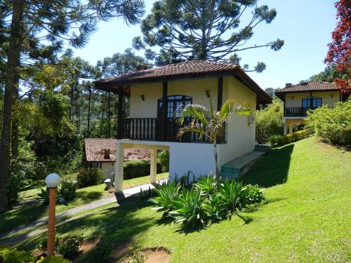 a small house with a balcony in a yard at Pousada Lua e Sol in Santo Antônio do Pinhal