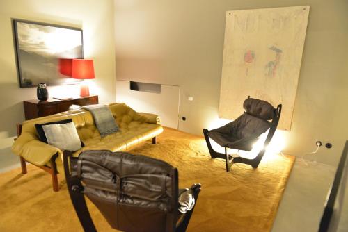 a living room with a couch and a chair at Raw Culture Art & Lofts Bairro Alto in Lisbon