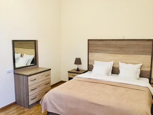 a bedroom with a large bed and a large mirror at Jermuk Moscow Health Resort in Jermuk