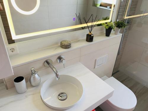 a white bathroom with a sink and a mirror at Natal Gian in Ischgl