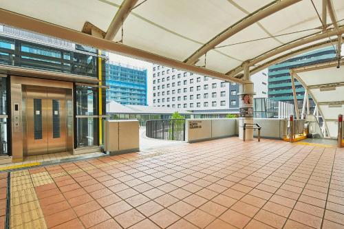 a building with a tiled floor and buildings at Hotel Lumiere Grande Nagareyama-Otakanomori in Nagareyama