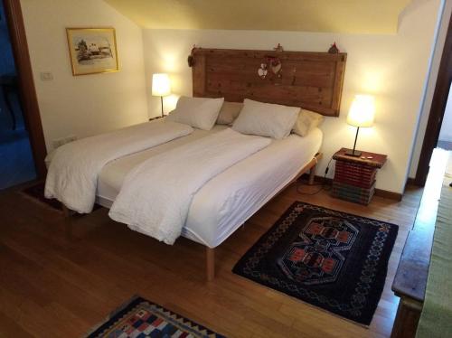 a bedroom with a large bed with white sheets and pillows at Great apartament in Feltre in Feltre