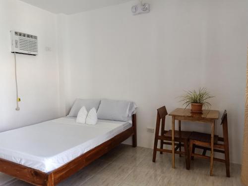 a bedroom with a bed and a table and a chair at RMB GUEST HOUSE in Siquijor