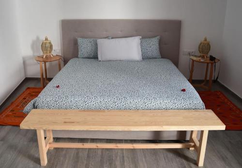 ein Schlafzimmer mit einem Bett mit einer Holzbank darauf in der Unterkunft Riad Dar DARRE in Marrakesch