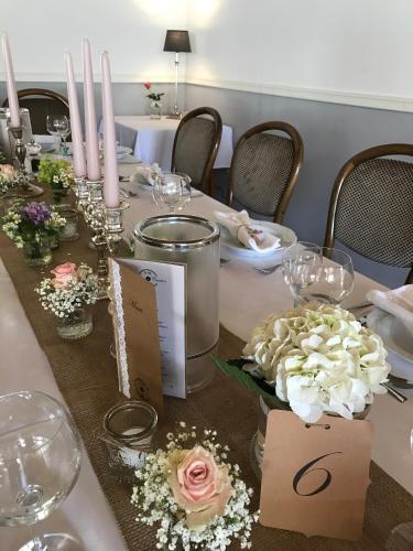 a table with flowers and wine glasses on it at Hotel Gasthuus Spieskamer in Hasselberg