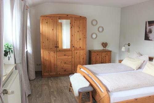 a bedroom with two beds and a wooden cabinet at Hotel Gasthuus Spieskamer in Hasselberg
