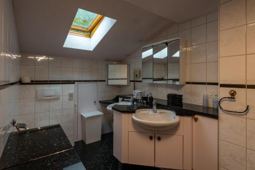 a bathroom with a sink and a skylight at Landgasthof Farnsburg in Ormalingen