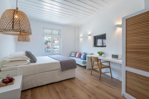 a white bedroom with a bed and a desk at Upper Hydra in Hydra
