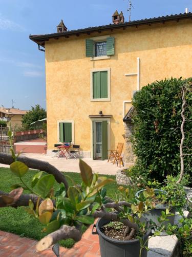 uma casa com um jardim com plantas em frente em A casa di Hugo em Marano di Valpolicella