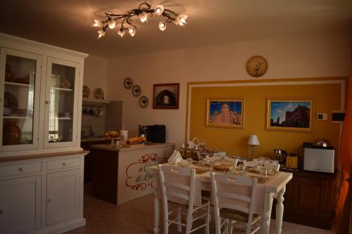 kuchnia ze stołem z krzesłami i zegarem na ścianie w obiekcie A Casa di Laura w mieście Occhiobello