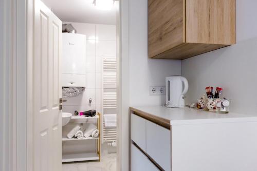 una pequeña cocina con armarios blancos y fregadero en City Apartment an der Caracalla Therme, en Baden-Baden