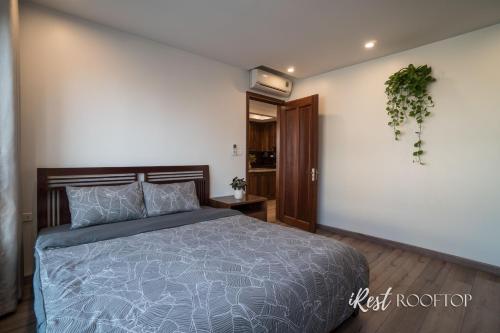 a bedroom with a bed and a plant on the wall at Irest Apartment in Hanoi