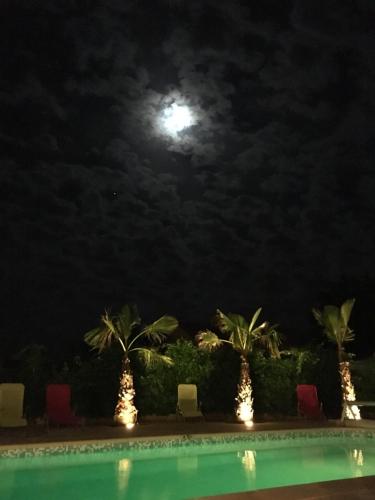 einen Vollmond über einem Swimmingpool in der Nacht in der Unterkunft Les cigales des prés Studio in Aups