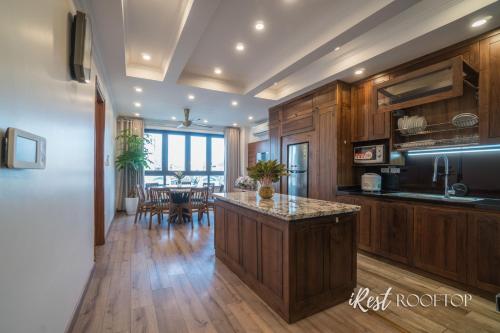 a kitchen with wooden cabinets and a table with chairs at Irest Apartment in Hanoi