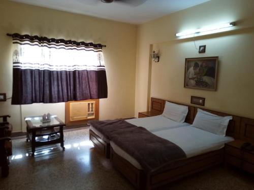 een slaapkamer met een groot bed en een raam bij Hotel Lakeview in Bhuj
