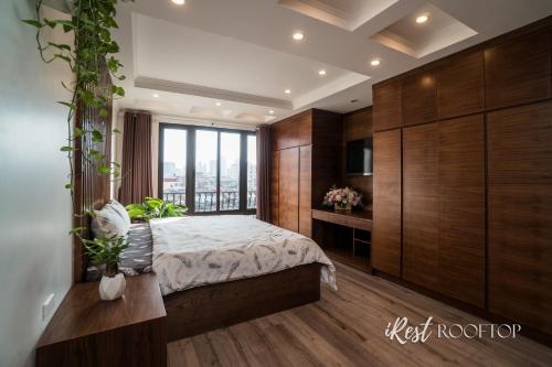 a bedroom with a bed and a large window at Irest Apartment in Hanoi