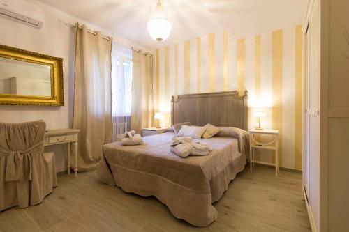 a bedroom with a bed with towels on it at Il Gioiello B&B in Marina di Pietrasanta