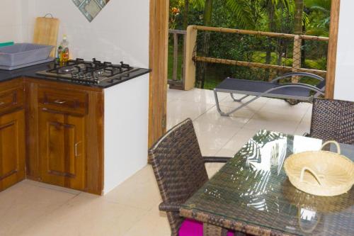 a kitchen with a stove and a table and a patio at La Batie selfcatering Apartment in Beau Vallon