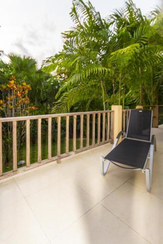 a black chair sitting on a balcony next to a fence at La Batie selfcatering Apartment in Beau Vallon