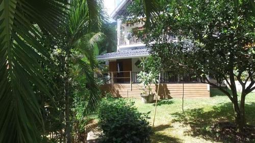 a house in the middle of a yard with trees at La Batie selfcatering Apartment in Beau Vallon