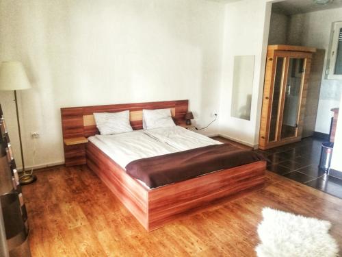 a bed in a room with a wooden floor at Tassi Halászcsárda-Kárász ház in Tass