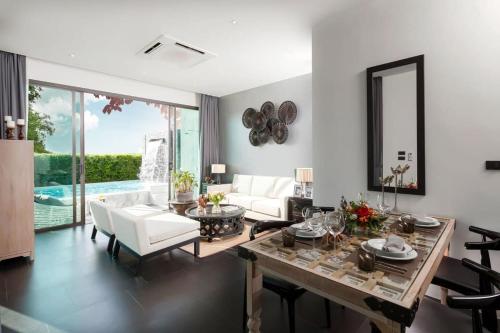 a living room with a table and white furniture at The Infinity Private Pool Villa in Phuket