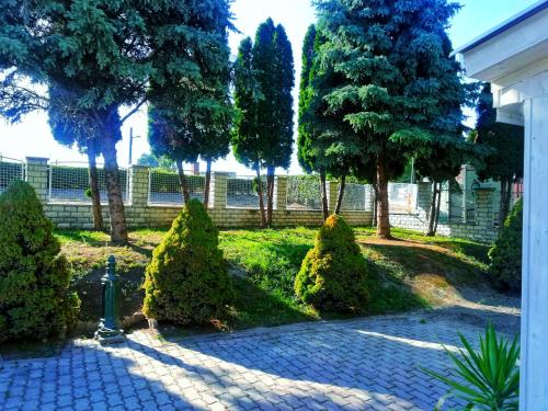 a garden with trees and bushes and a fire hydrant at Tassi Halászcsárda-Harcsa ház in Tass