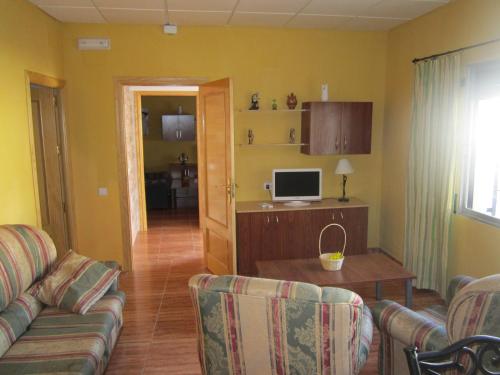 a living room with a couch and a desk with a computer at Apartamentos Venta Don Quijote in Almagro