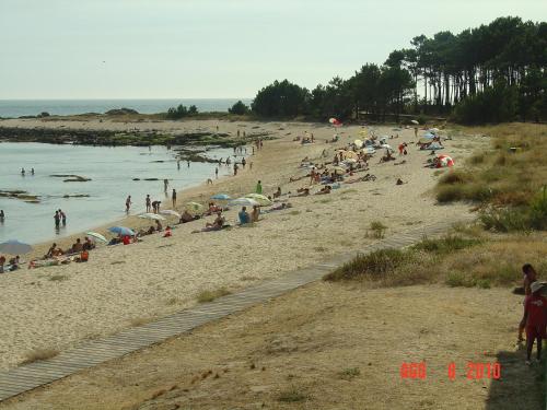 a crowd of people on a beach with umbrellas at Hotel Vila da Guarda in A Guarda