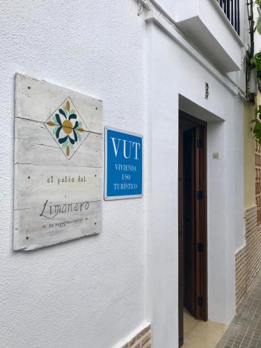 a sign on the side of a white building at El Patio del Limonero in Écija