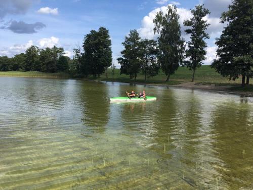 two people in a green boat in the water at Sterla - Masuria in Giżycko