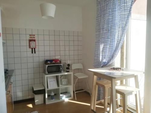 eine kleine Küche mit einem Tisch und einer Mikrowelle in der Unterkunft Oportobestview-Sun in Porto