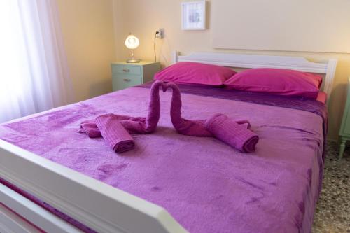 ein lila Bett mit Fingerspitzen drauf in der Unterkunft Afitos Beach Apartments in Afytos