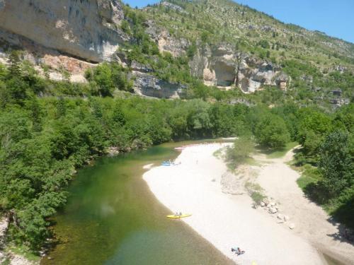 a view of a river with people on a beach at La maison d'Arnal in Sainte-Énimie