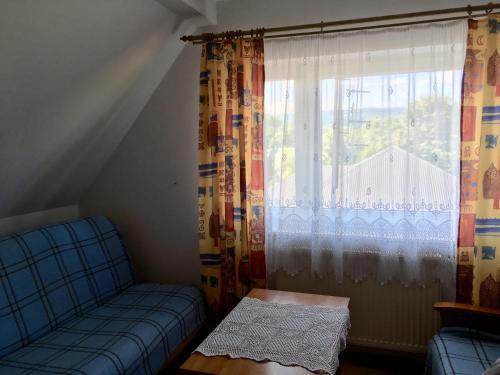 a living room with a couch and a window at Pokoje u Bożeny i Zbyszka in Lipie
