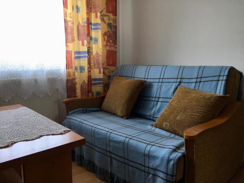 a blue couch in a room with a window at Pokoje u Bożeny i Zbyszka in Lipie