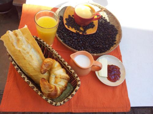a table with two baskets of breakfast foods and drinks at Hotel St-Antoine in Antananarivo