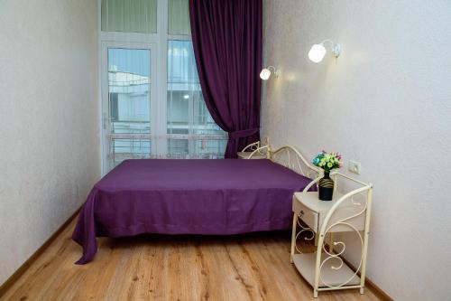 a bedroom with a purple bed and a window at Золотой Бугаз in Gribovka