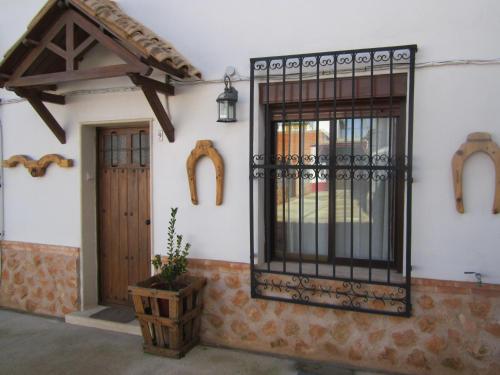a house with a gate and a door and a plant at Apartamentos Venta Don Quijote in Almagro