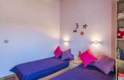 a bedroom with purple and pink pillows on a bed at HOUSE NEXT TO THE SEA in Ermioni