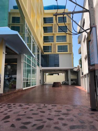an empty parking lot in front of a building at โรงแรมโกลว์ รัตนา เพลส in Songkhla