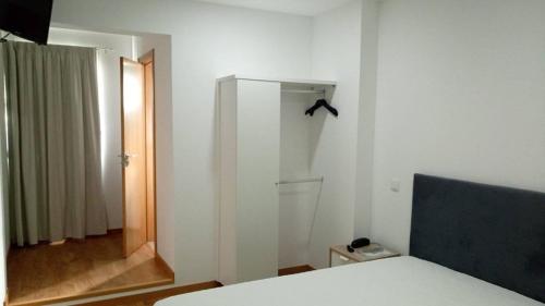 een slaapkamer met een bed, een spiegel en een raam bij Hotel Bem Estar in Lousã