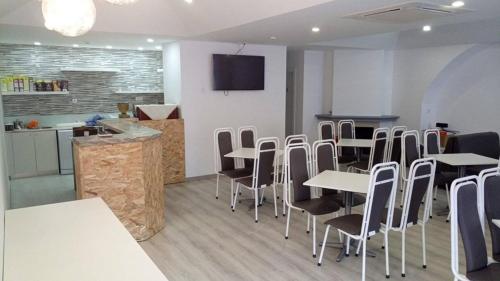 a restaurant with tables and chairs and a kitchen at Hotel Bem Estar in Lousã