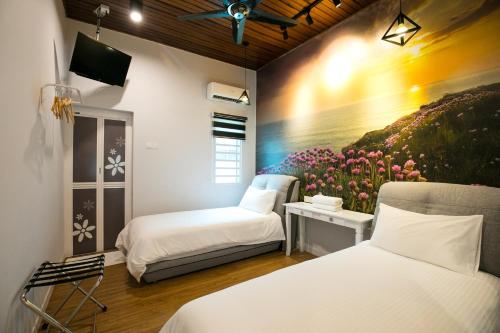 a room with two beds and a painting on the wall at Canning 33 in Ipoh