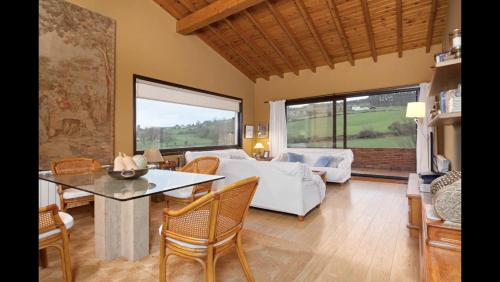 Una sala de estar con una cama, una mesa y sillas. en El Mazo Meruelo, en San Miguel de Meruelo